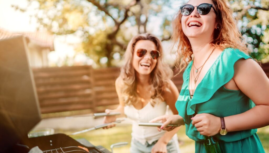 Two girlfriends having a good time and barbequing