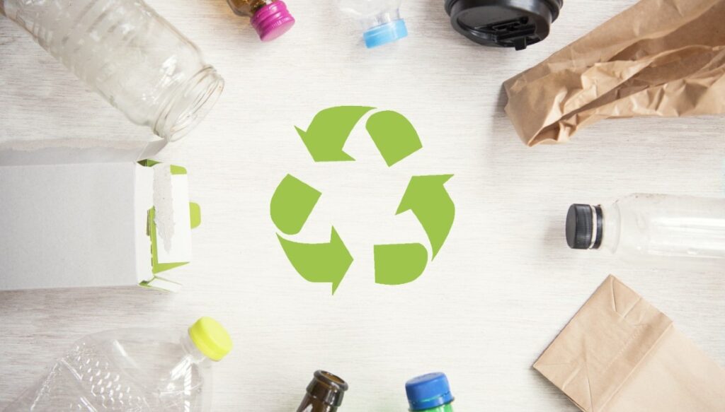 Recycling Symbol Surrounded by Various Recyclable Materials and Products