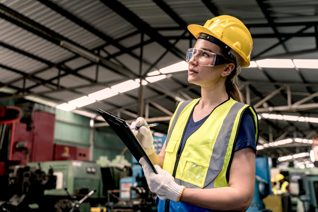 A technician checking equipment on a factory floor