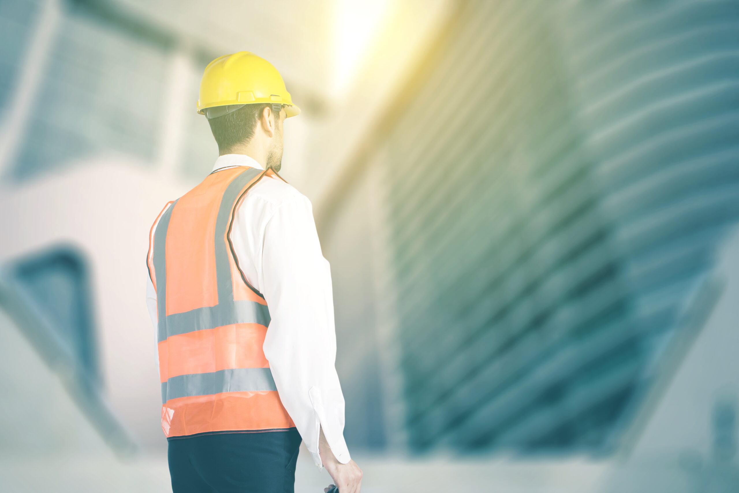 Low angle view male engineer stand with skyscraper scaled