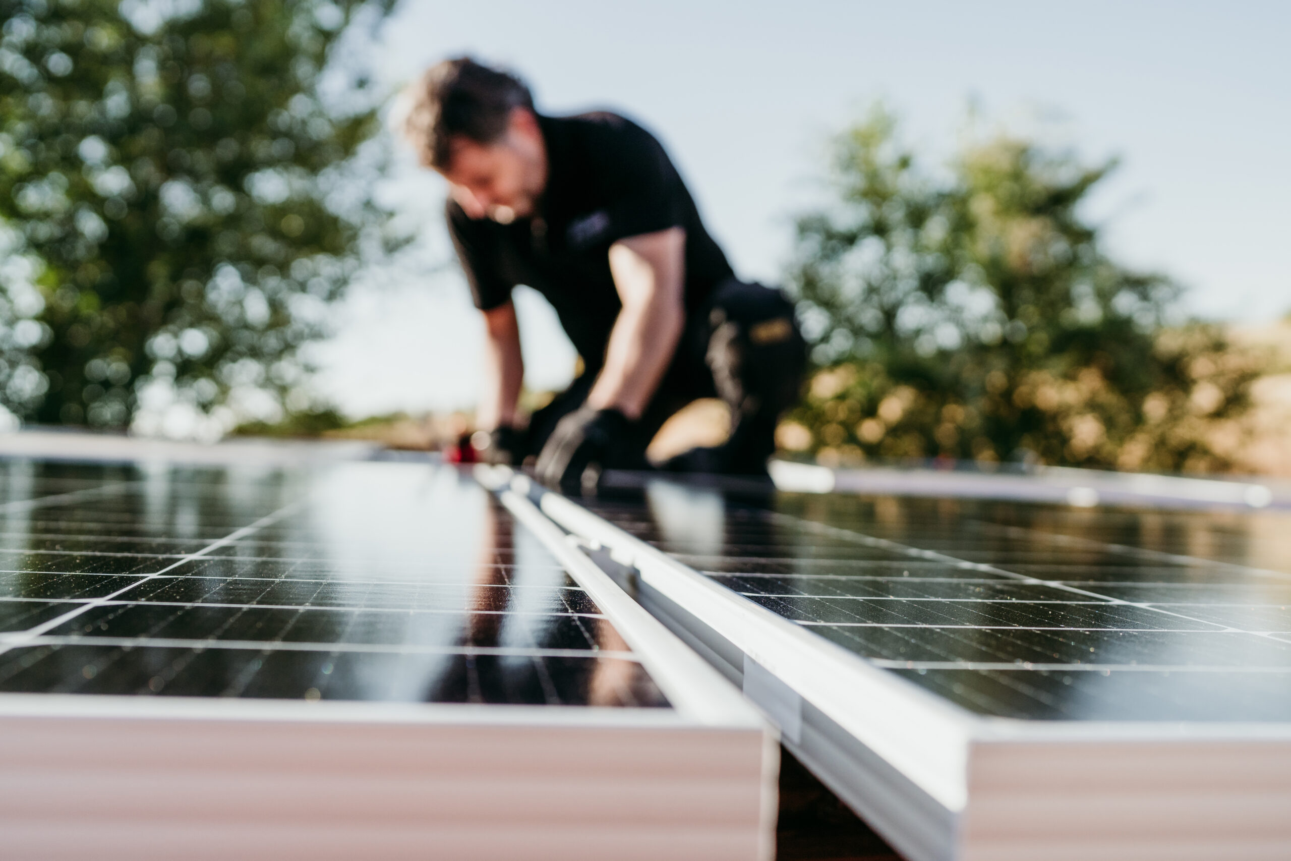 Mature technician man assembling solar panels house roof self consumptionfocus foreground scaled