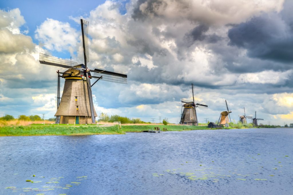 Brown and black windmill beside body of water 1024x682 1