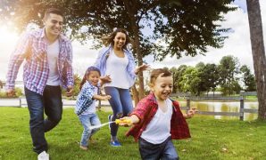 Happy family running around the park