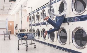 A women inside a washing machine at a laundromat