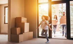Happy family with cardboard boxes in new house at moving day.