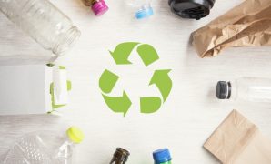Recycling Symbol Surrounded by Various Recyclable Materials and Products